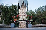 Цветы и свечи у памятника мирным жителям